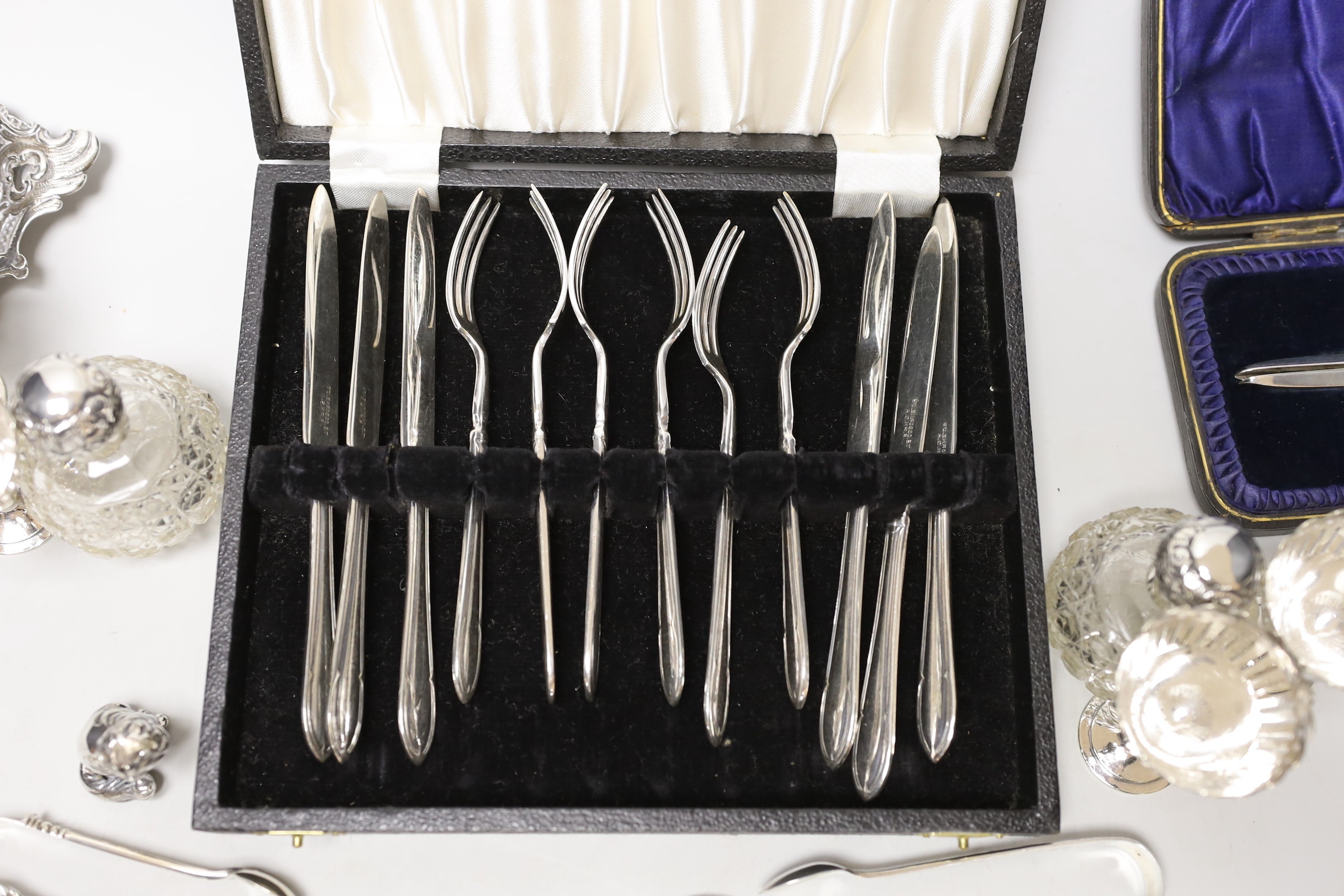 Sundry small silverwares including flatware, a pair of mounted glass scent bottles, a white metal German dish and minor plated items.